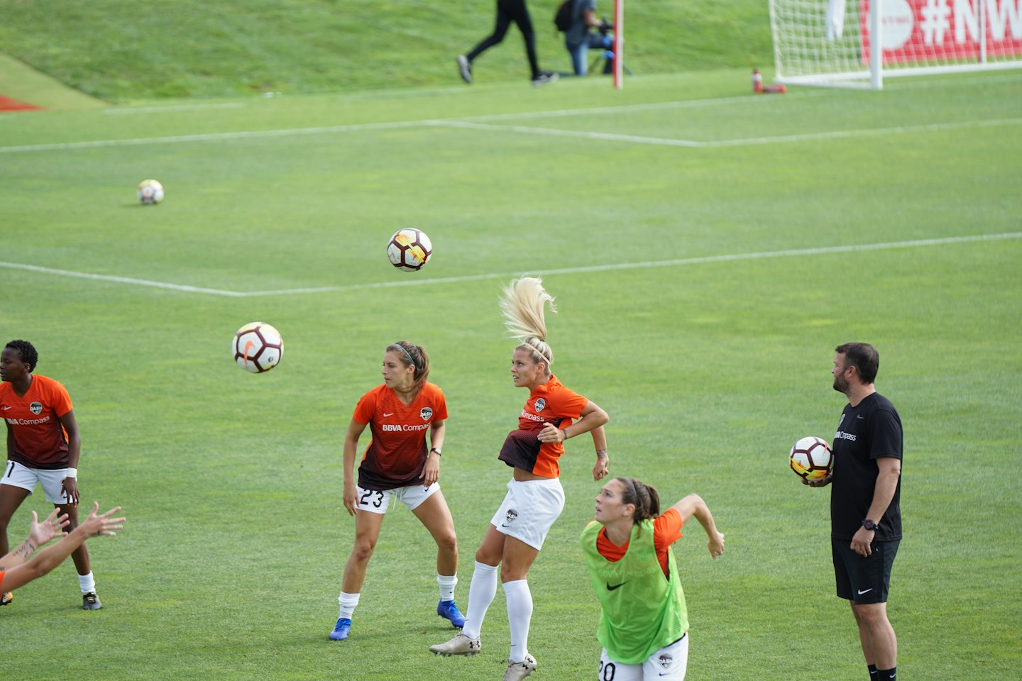 Soccer team and coach practicing drills on an outdoor field.